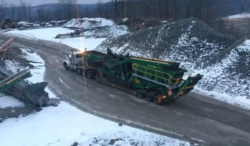 Stagecoach Mccloskey crushing plant being transported on a lowboy during winter